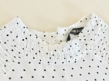 Elastic smocking around neckline and shoulers on a ZARA black and white polka dot top.